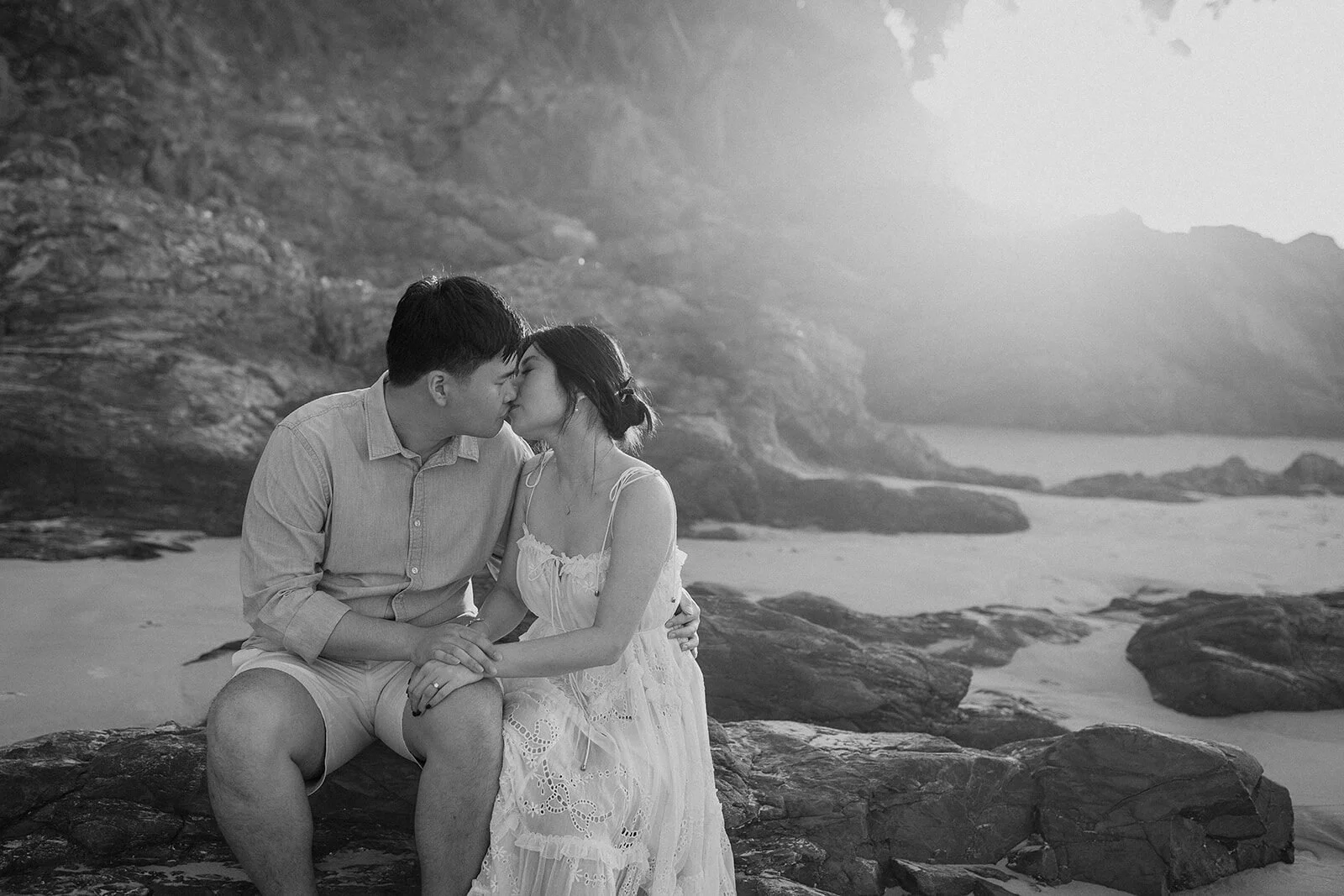 Black and white of the couple kissing on the rocks, Maggie and William's pre-wedding photos in Byron Bay
