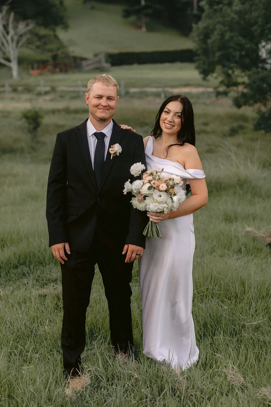 Couple posing in the long grass, Kobi and Darren's elopement at Butterfly Lane, Byron Bay hinterland