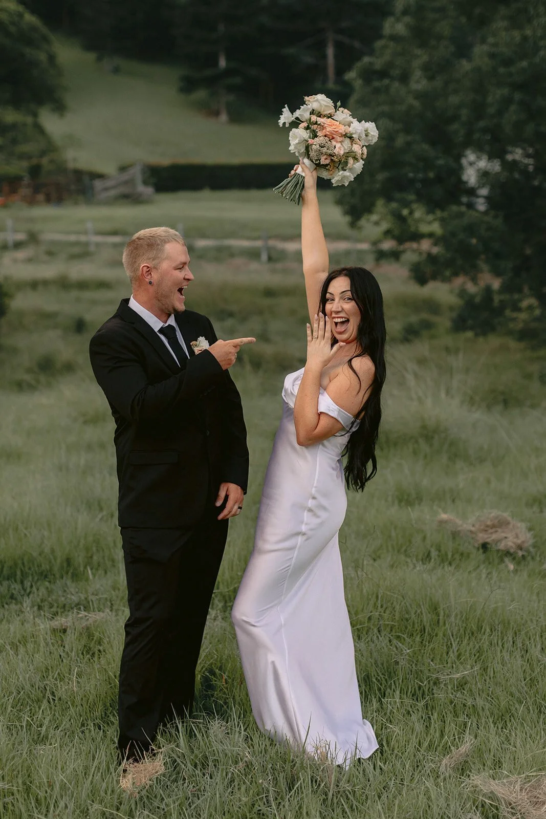 Bride laughing and raising her bouquet, Kobi and Darren's elopement at Butterfly Lane, Byron Bay hinterland