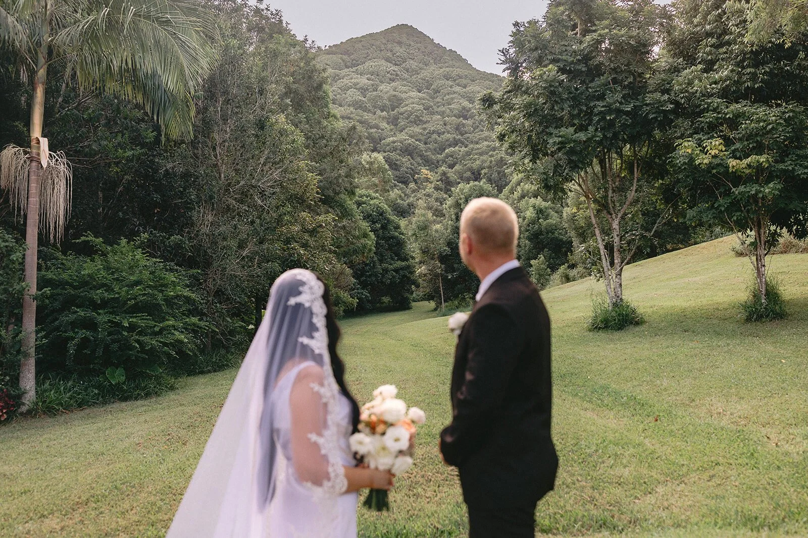 Bride in a lace veil facing the groom, Kobi and Darren's elopement at Butterfly Lane, Byron Bay hinterland
