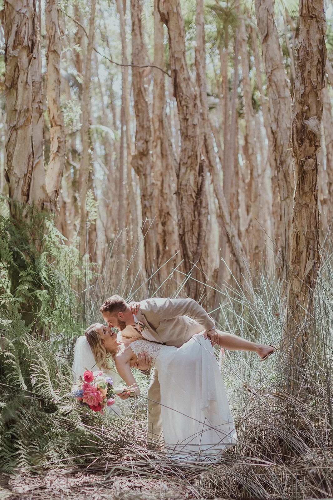 Groom dipping the bride in the paperbark forest, Eliza and Greg's elopement at Broken Head, Byron Bay