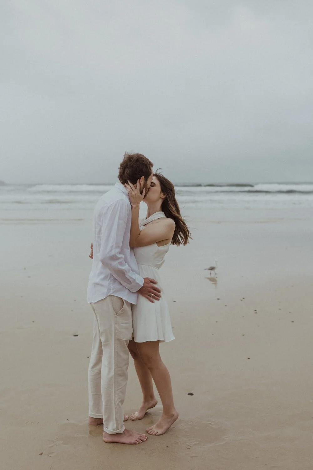 Couple kissing on a stormy beach, Yoanne and Elisa's rainy elopement at Broken Head, Byron Bay
