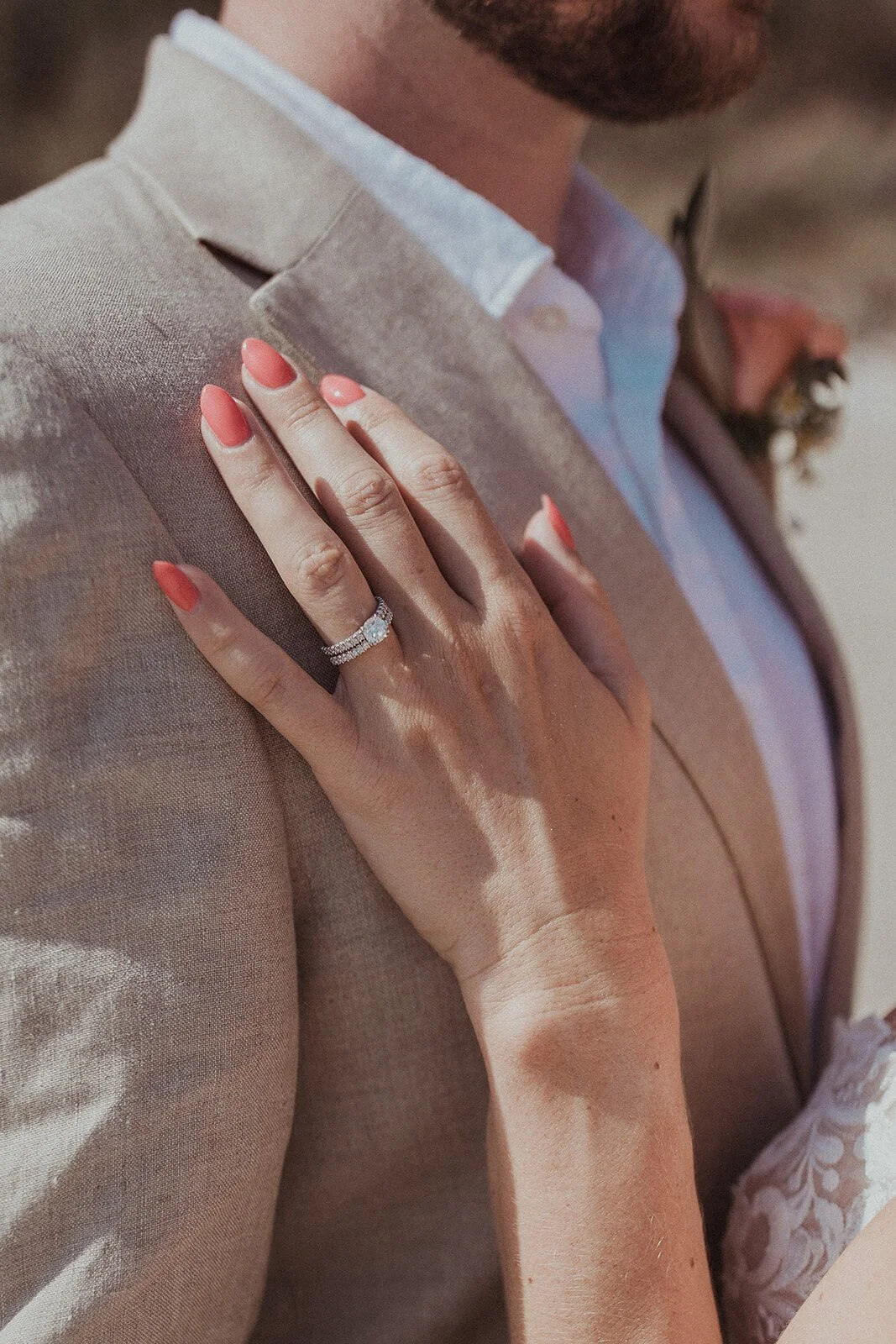 Detail of the bride's hand with a ring on the groom's suit, Eliza and Greg's elopement at Broken Head, Byron Bay
