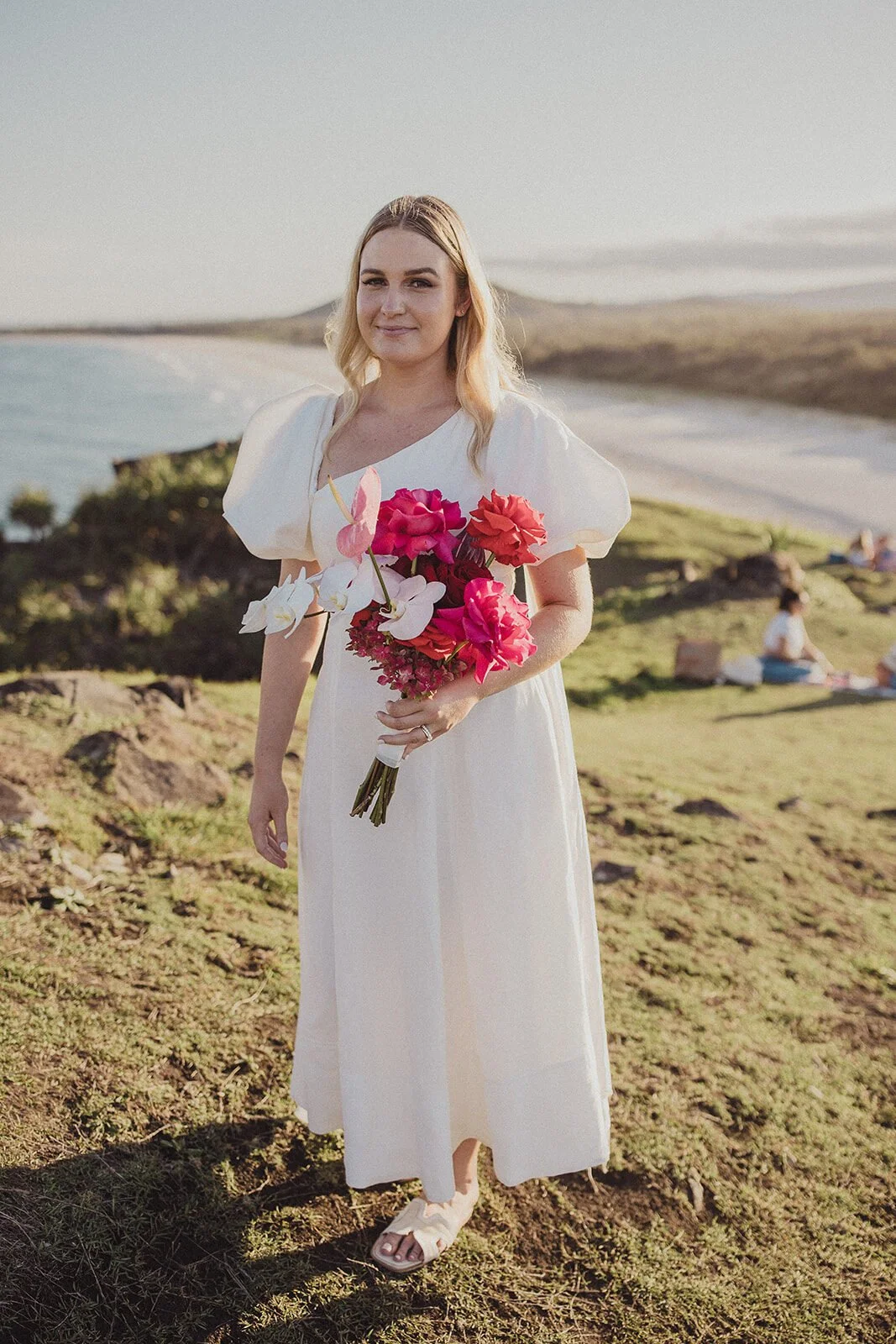 Bride holding a bright pink bouquet on the headland, Brittany and Mark's elopement at Cabarita Beach, Northern Rivers