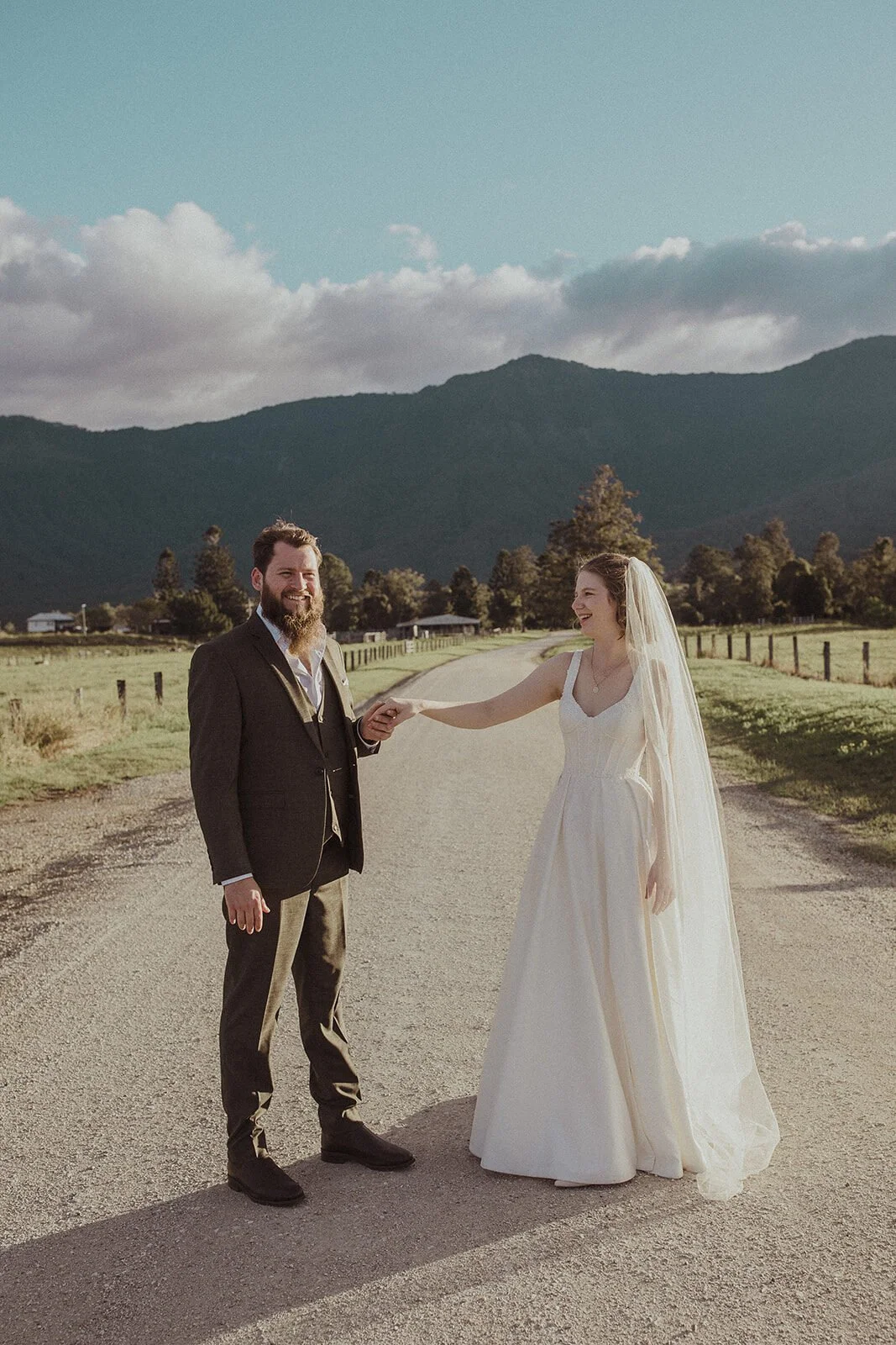 Groom taking the bride's hand on the road, Sam and Tom's elopement at Highfield Farm, Northern Rivers