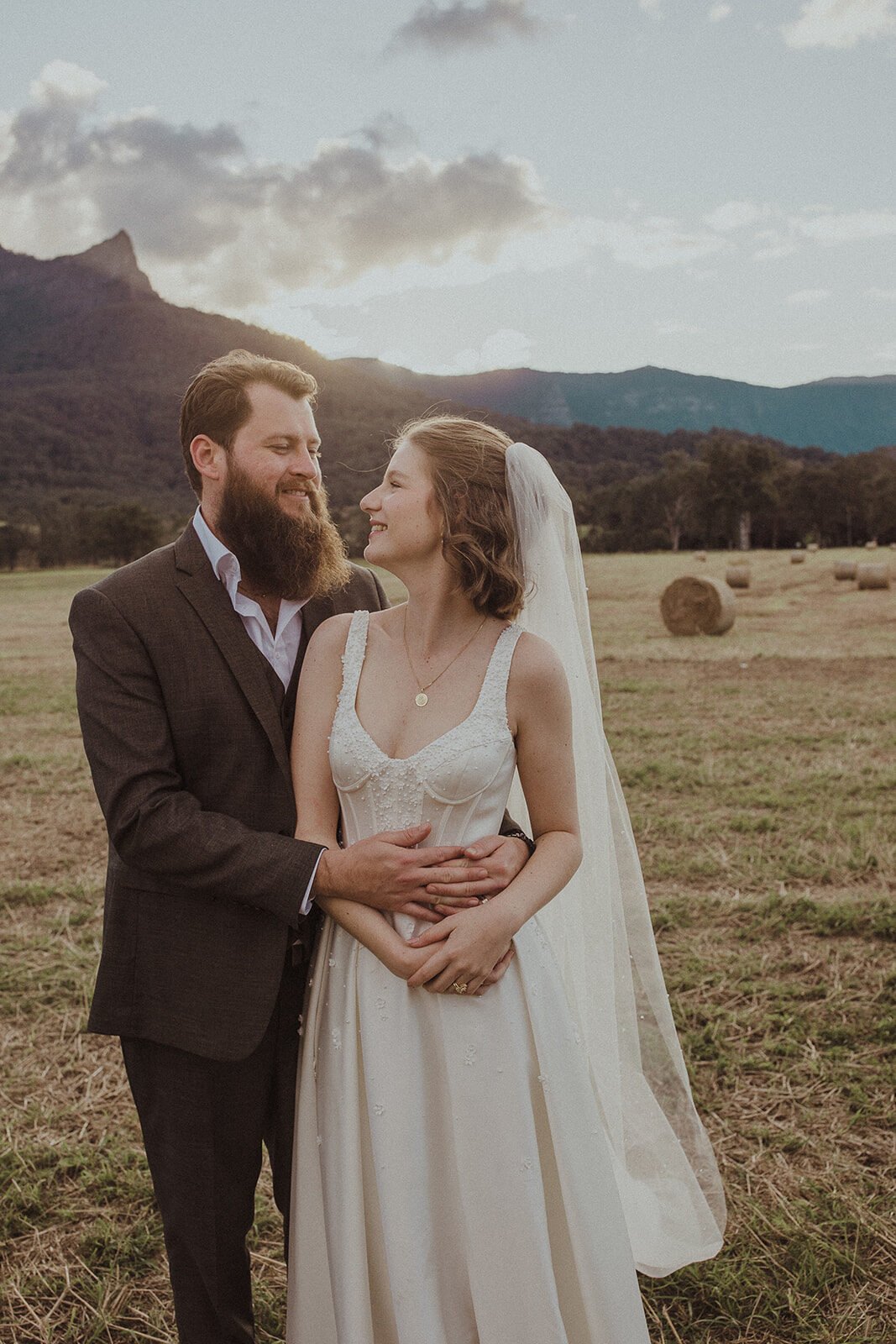 Couple laughing together in the field at sunset, Sam and Tom's elopement at Highfield Farm, Northern Rivers