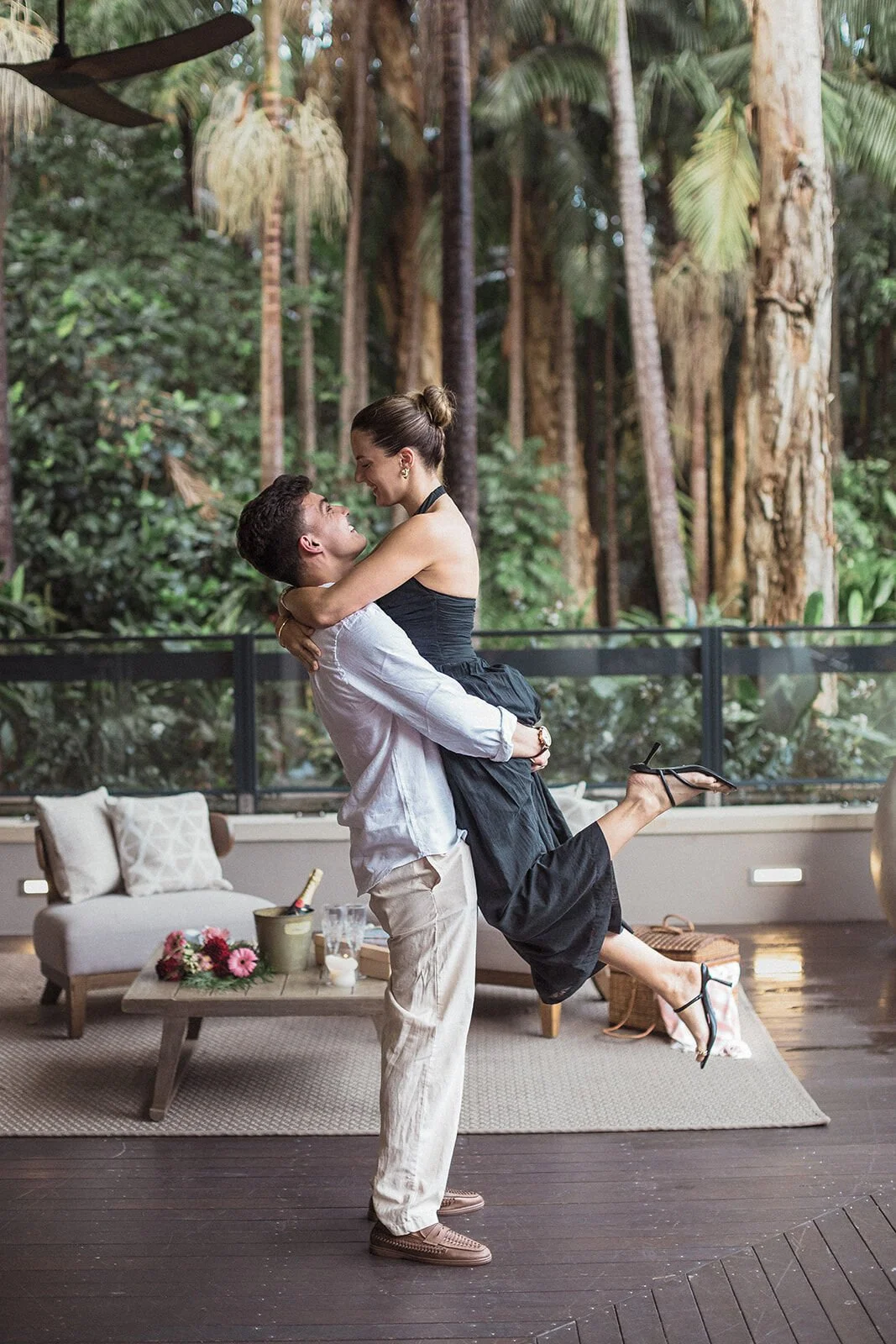 Man lifting and spinning his fiancée on the rainforest deck, Ben and Chloe's marriage proposal in Byron Bay