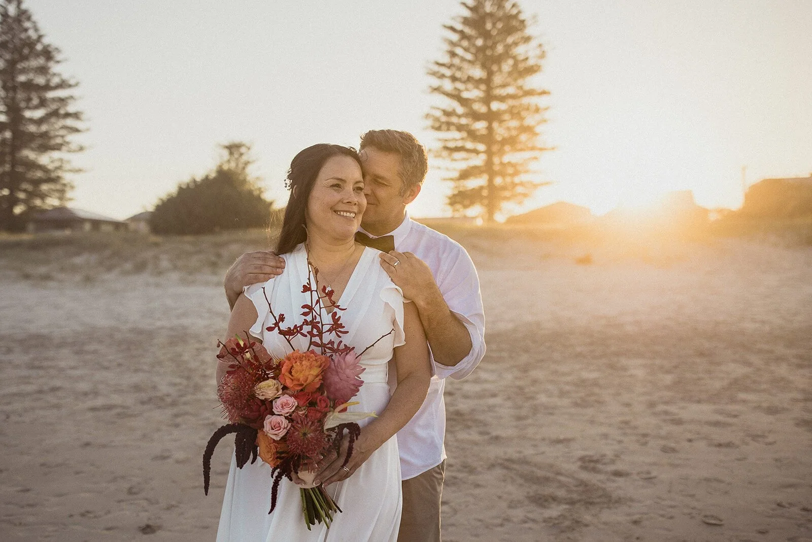 Couple embracing on the beach at sunset, Maritess and Mark's elopement at Lennox Head