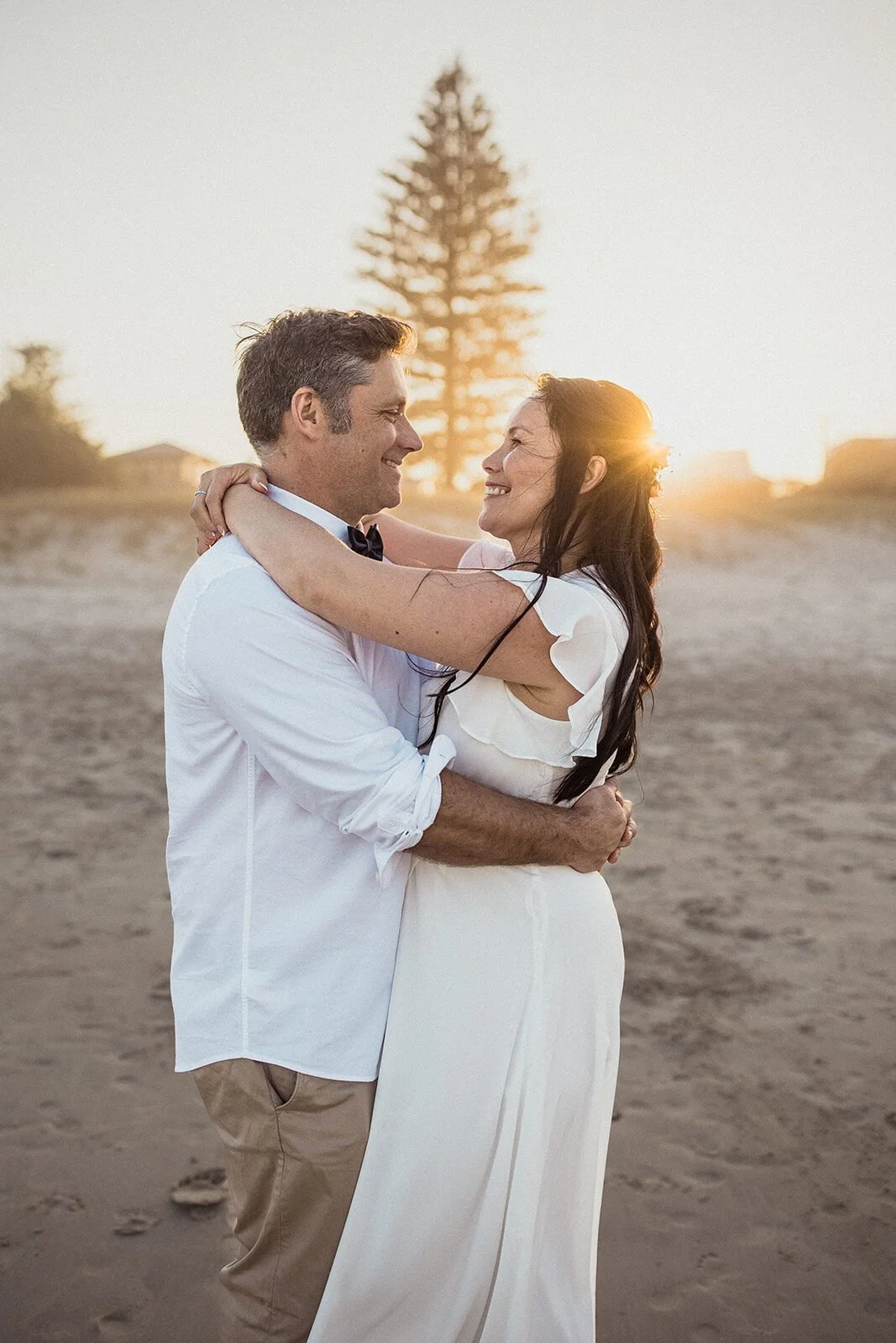 Couple hugging with the sun behind, Maritess and Mark's elopement at Lennox Head