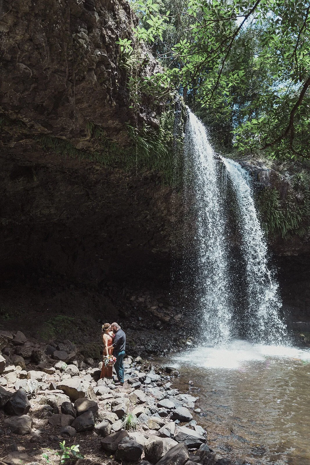 Couple embracing on the rocks below the waterfall, Sara and Graeme's elopement at Killen Falls, Northern Rivers