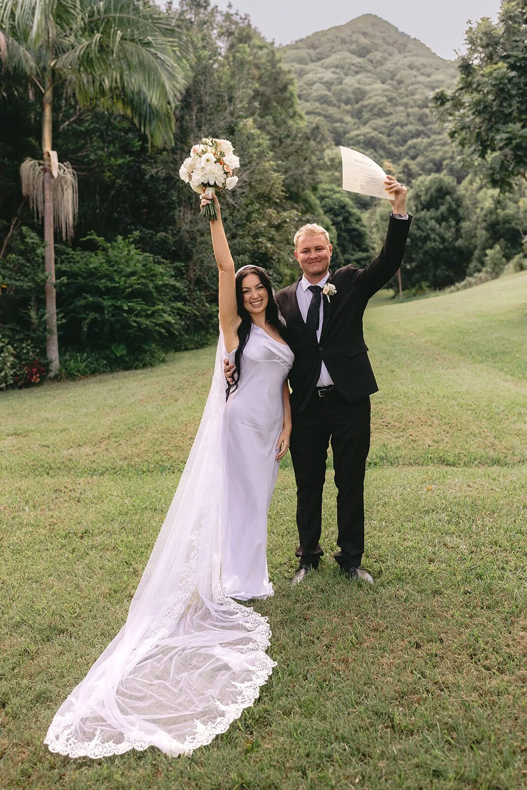 Couple celebrating as the bride raises her bouquet, Kobi and Darren's elopement at Butterfly Lane, Byron Bay hinterland