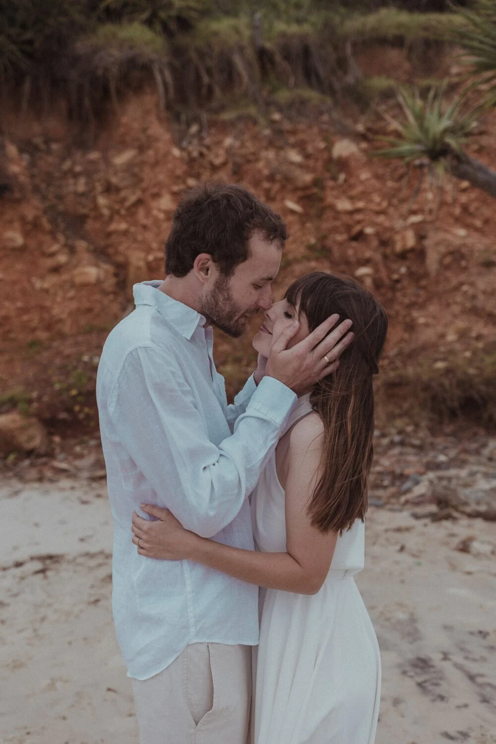 Couple kissing near the red cliffs, Yoanne and Elisa's rainy elopement at Broken Head, Byron Bay