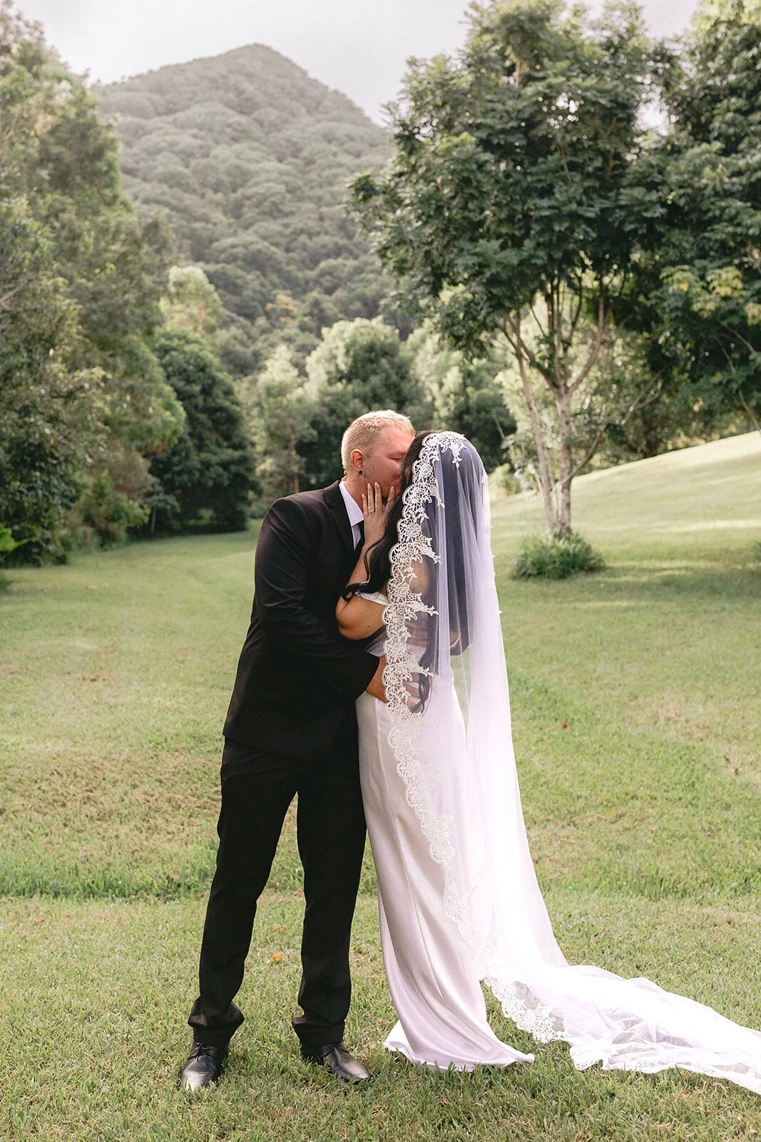 Couple kissing on the lawn, Kobi and Darren's elopement at Butterfly Lane, Byron Bay hinterland