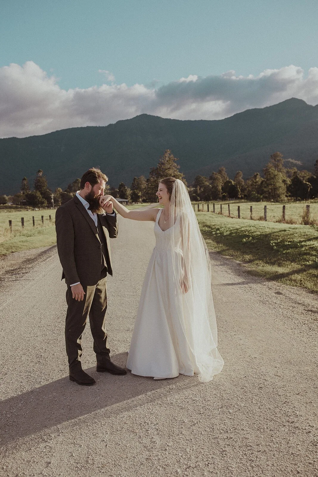 Groom kissing the bride's hand on the country road, Sam and Tom's elopement at Highfield Farm, Northern Rivers