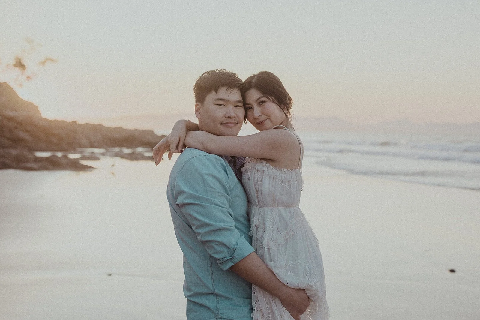 Couple hugging on the beach at dusk, Maggie and William's pre-wedding photos in Byron Bay