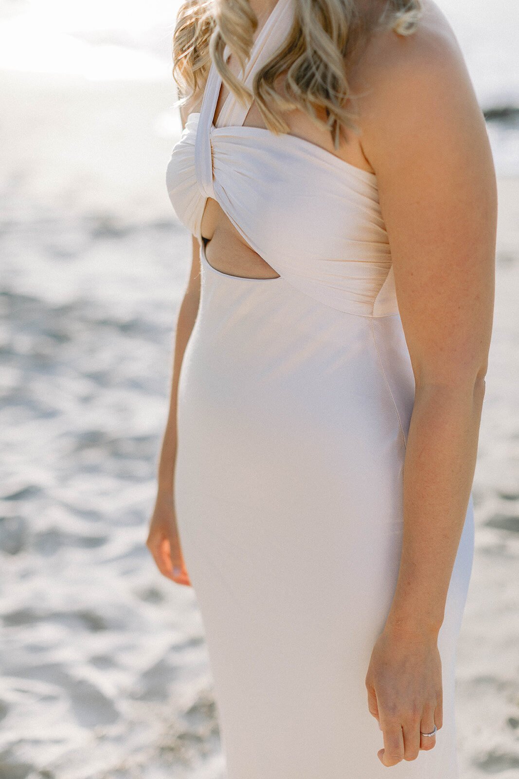 Detail of the bride's white dress with the sea behind, Abby and James' elopement at Little Wategos Beach, Byron Bay