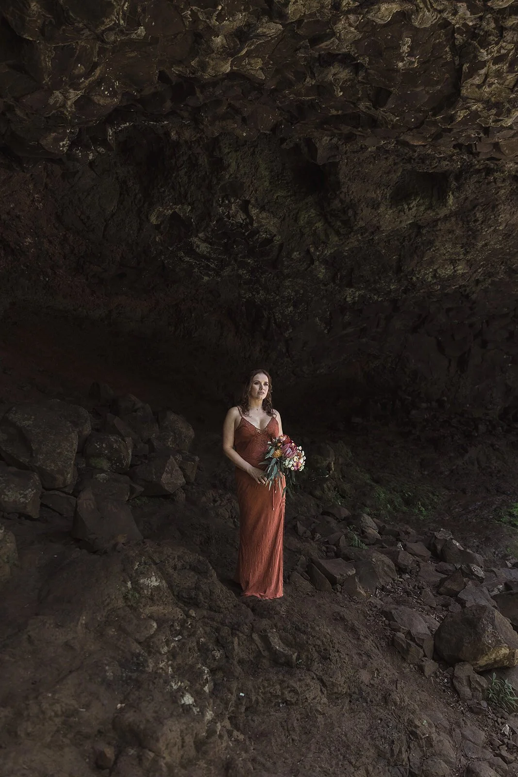 Bride standing small in the cave, Sara and Graeme's elopement at Killen Falls, Northern Rivers