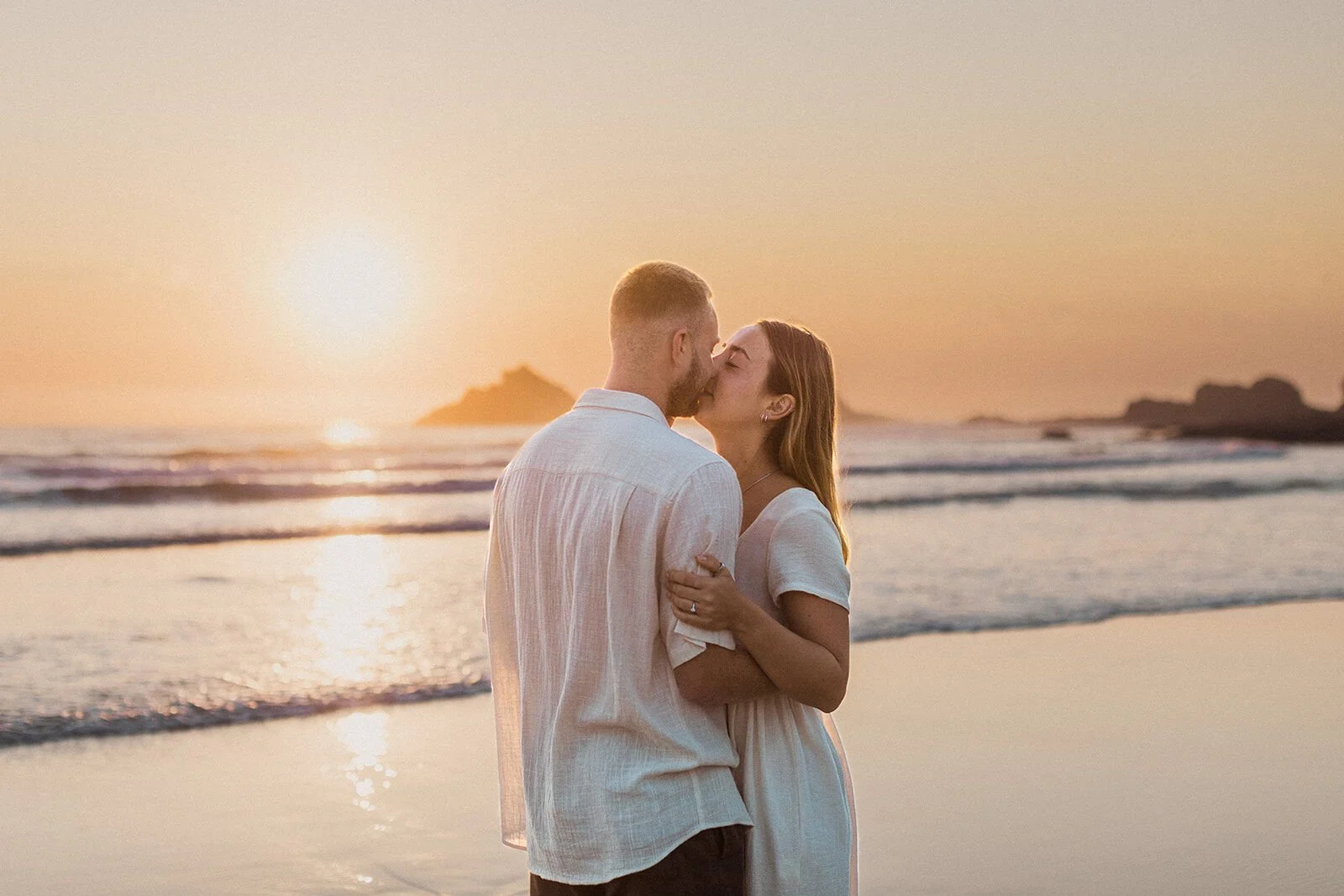 Couple kissing with the sun low behind them, Charlie and Hannah's sunrise marriage proposal at Broken Head Beach, Byron Bay