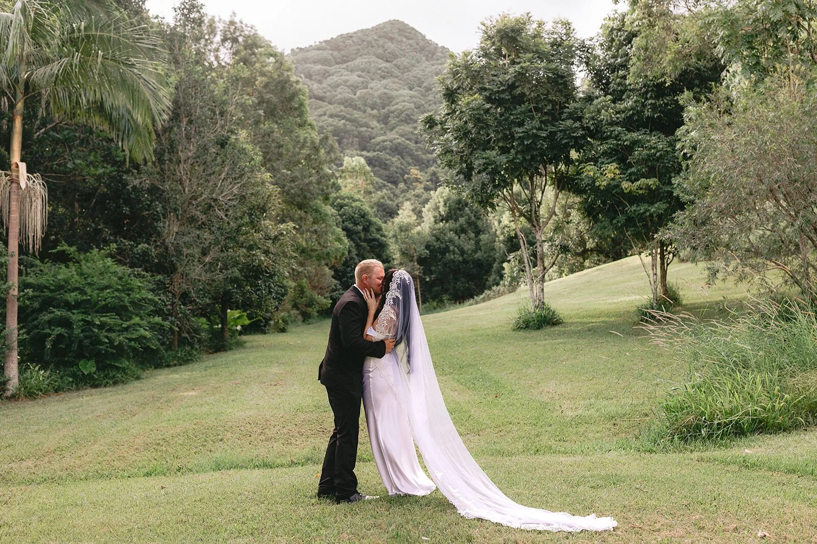 Couple embracing on the lawn, Kobi and Darren's elopement at Butterfly Lane, Byron Bay hinterland