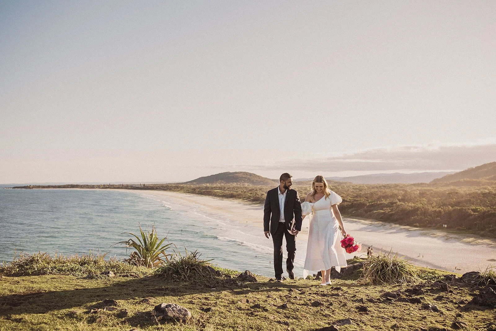 Couple walking hand in hand on the headland, Brittany and Mark's elopement at Cabarita Beach, Northern Rivers