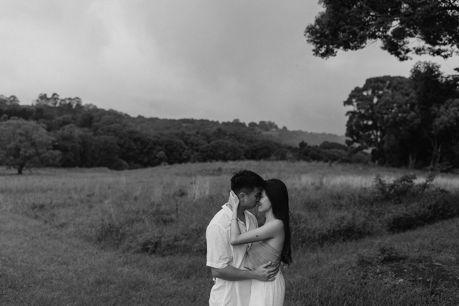 Black and white of the couple embracing with foreheads together in the misty paddock, Darien and Jacqui's picnic marriage proposal at Heartwood Farm, Byron Bay hinterland