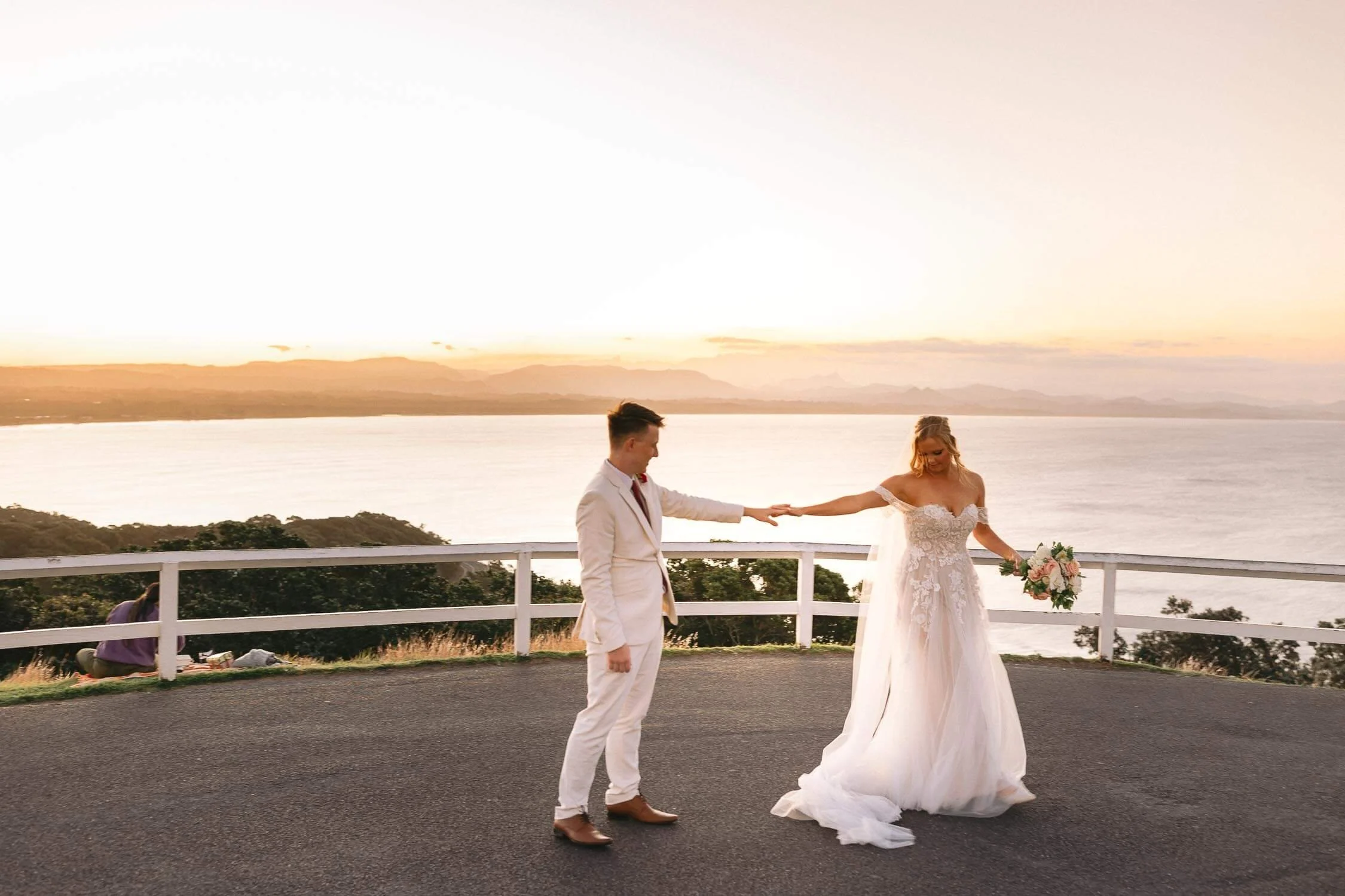 Bride and groom dancing at sunset beside the Cape Byron Lighthouse
