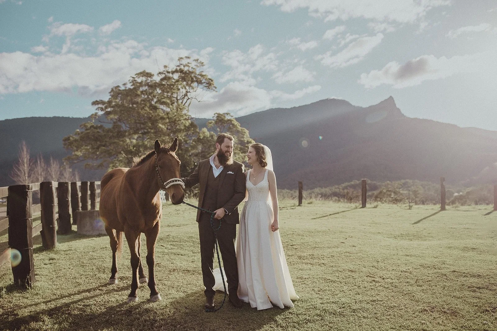 Bride and groom with a horse in a hinterland paddock with Mount Wollumbin behind, elopement photography Byron Bay and the Northern RiversByron Bay wedding at Cape Byron Lighthouse