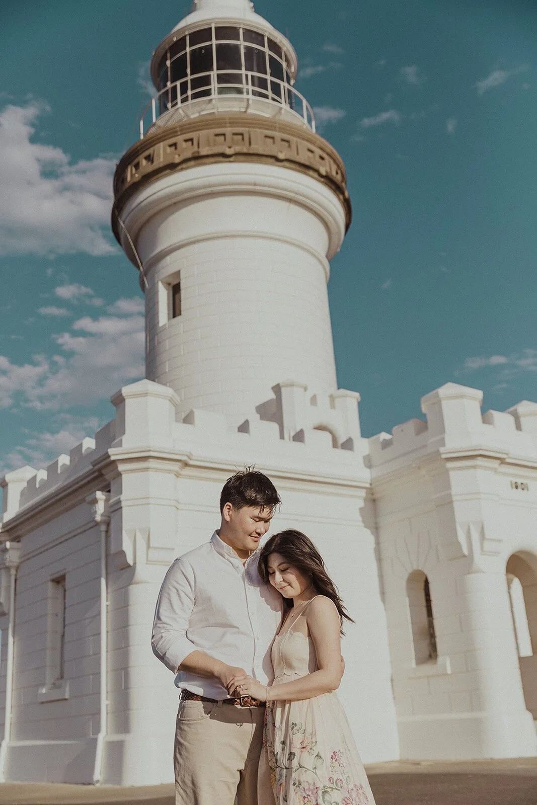 Couple embracing at the Cape Byron Lighthouse, Maggie and William's pre-wedding photos in Byron Bay