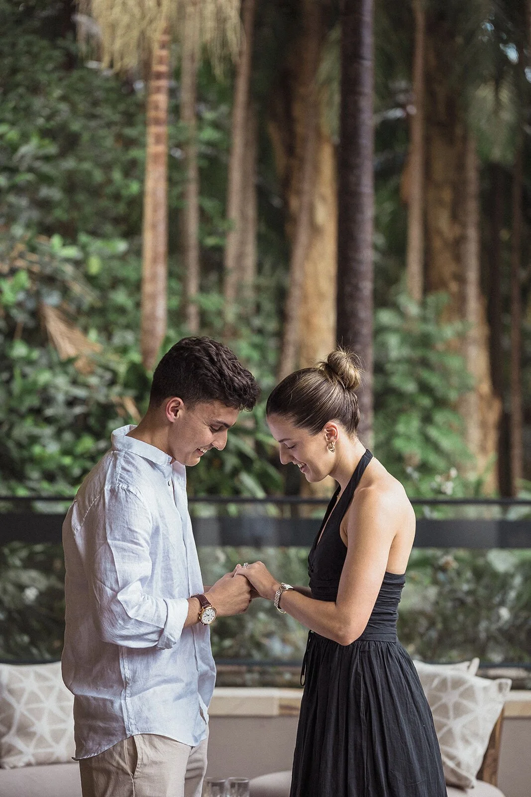 Couple admiring the new engagement ring, her in a black dress, Ben and Chloe's marriage proposal in Byron Bay
