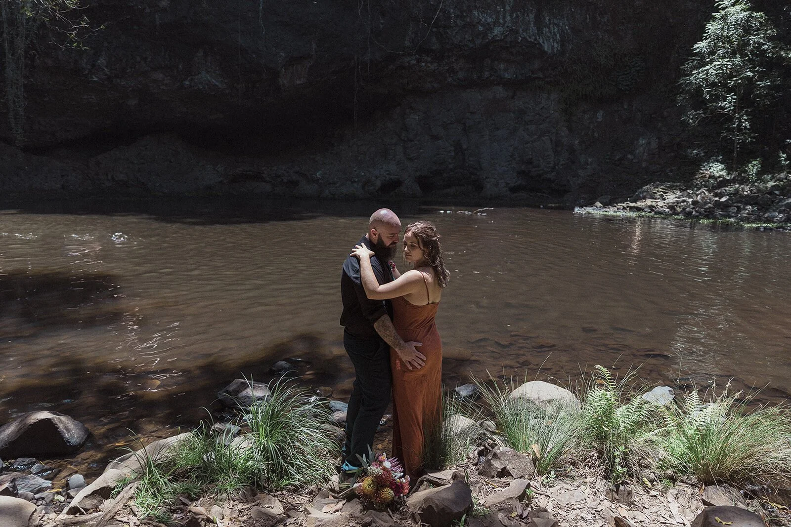 Couple embracing beside the waterhole, Sara and Graeme's elopement at Killen Falls, Northern Rivers
