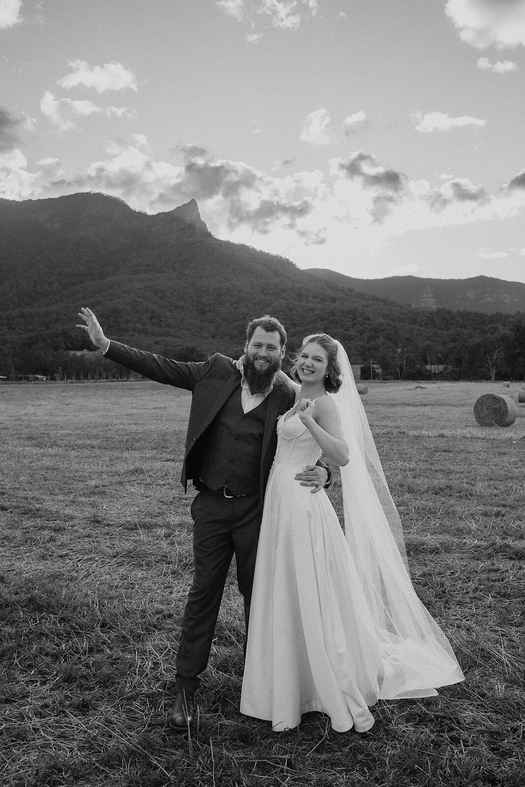 Black and white of the couple cheering in the field, Sam and Tom's elopement at Highfield Farm, Northern Rivers