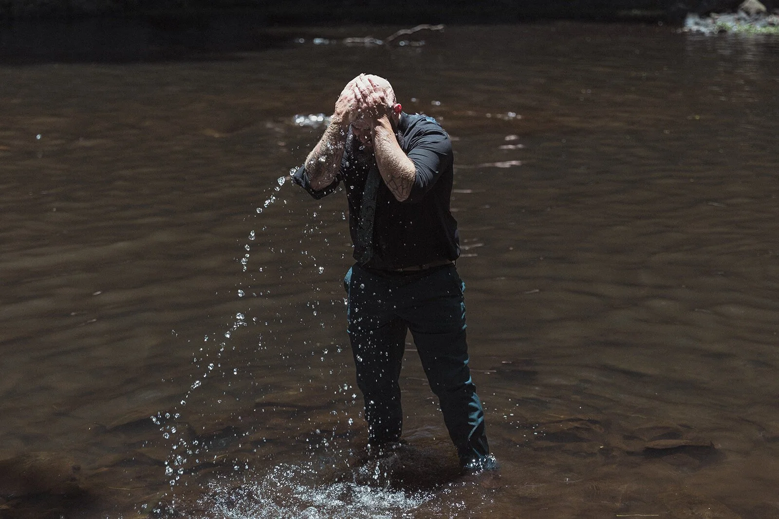 Groom splashing water over his face in the pool, Sara and Graeme's elopement at Killen Falls, Northern Rivers