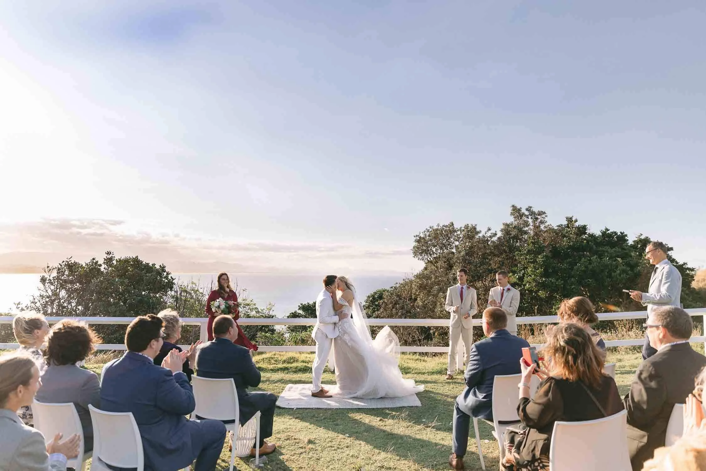 Bride and groom’s ceremony kiss on the lawn at the Cape Byron Lighthouse
