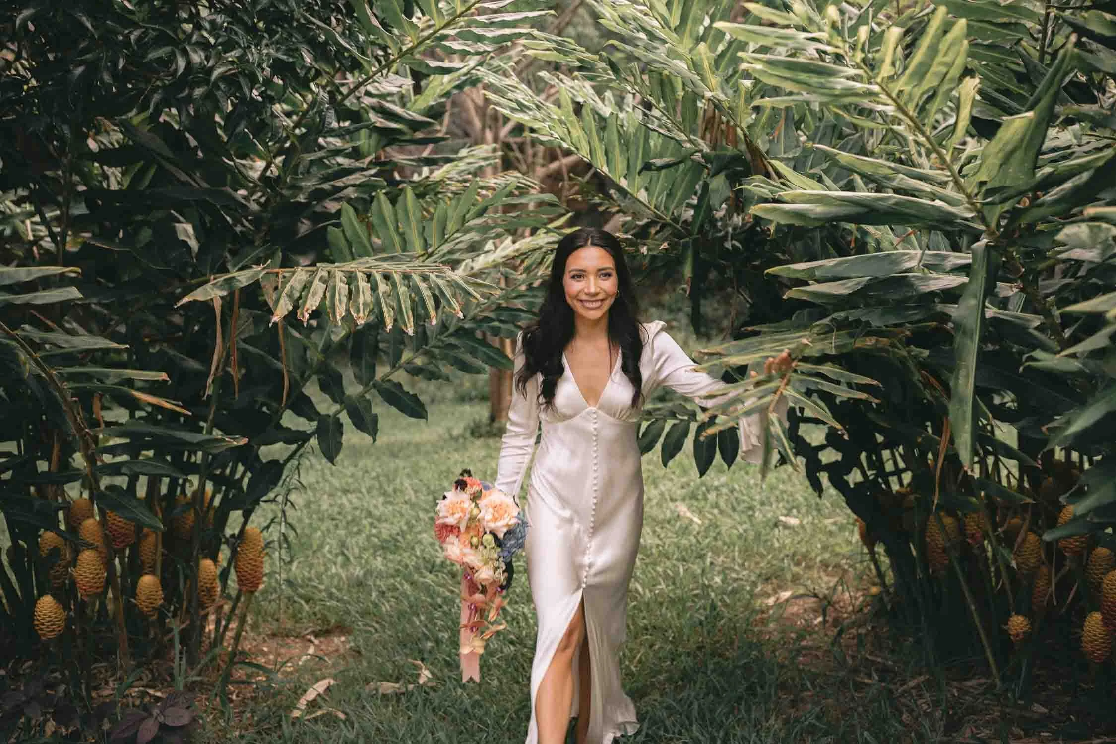 Bride walking through a tropical garden in the Byron hinterland during her elopement