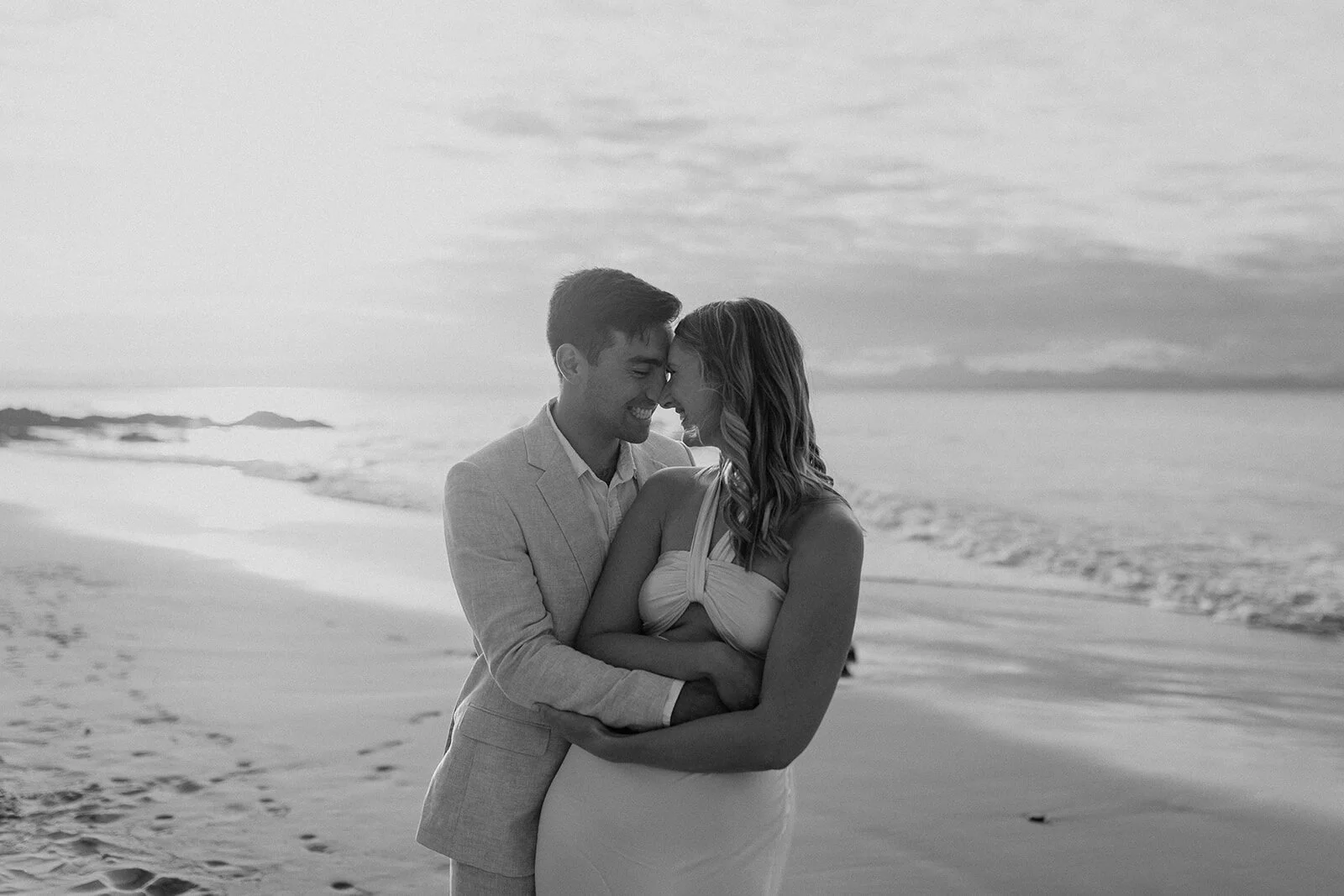 Black and white of the couple embracing forehead to forehead, Abby and James' elopement at Little Wategos Beach, Byron Bay