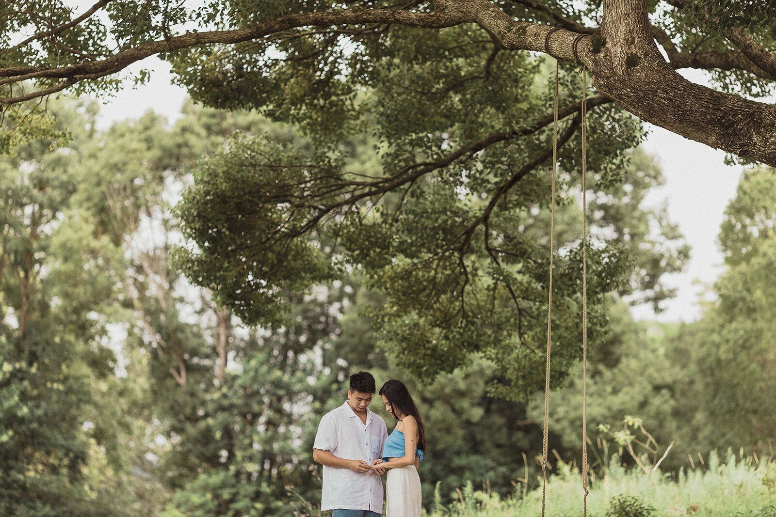 Couple admiring the ring in the paddock beside the rope swing, Darien and Jacqui's picnic marriage proposal at Heartwood Farm, Byron Bay hinterland