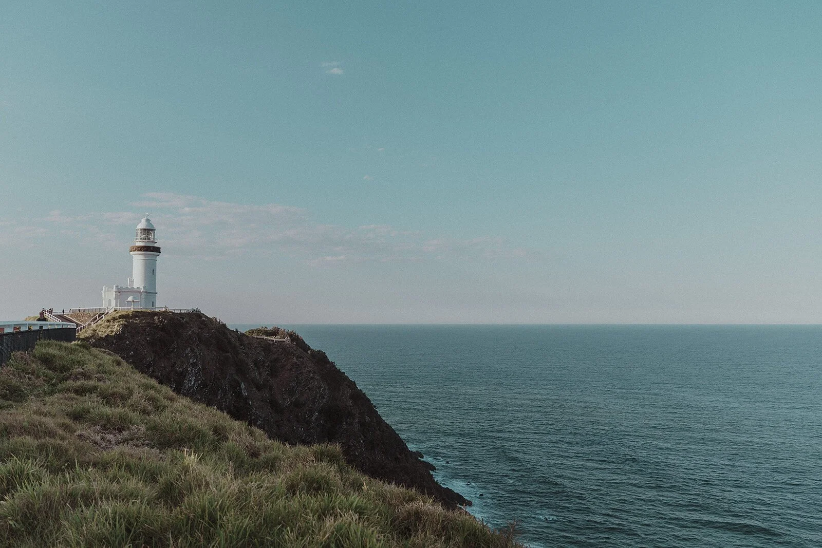 Cape Byron Lighthouse on the headland above the sea, Maggie and William's pre-wedding photos in Byron Bay