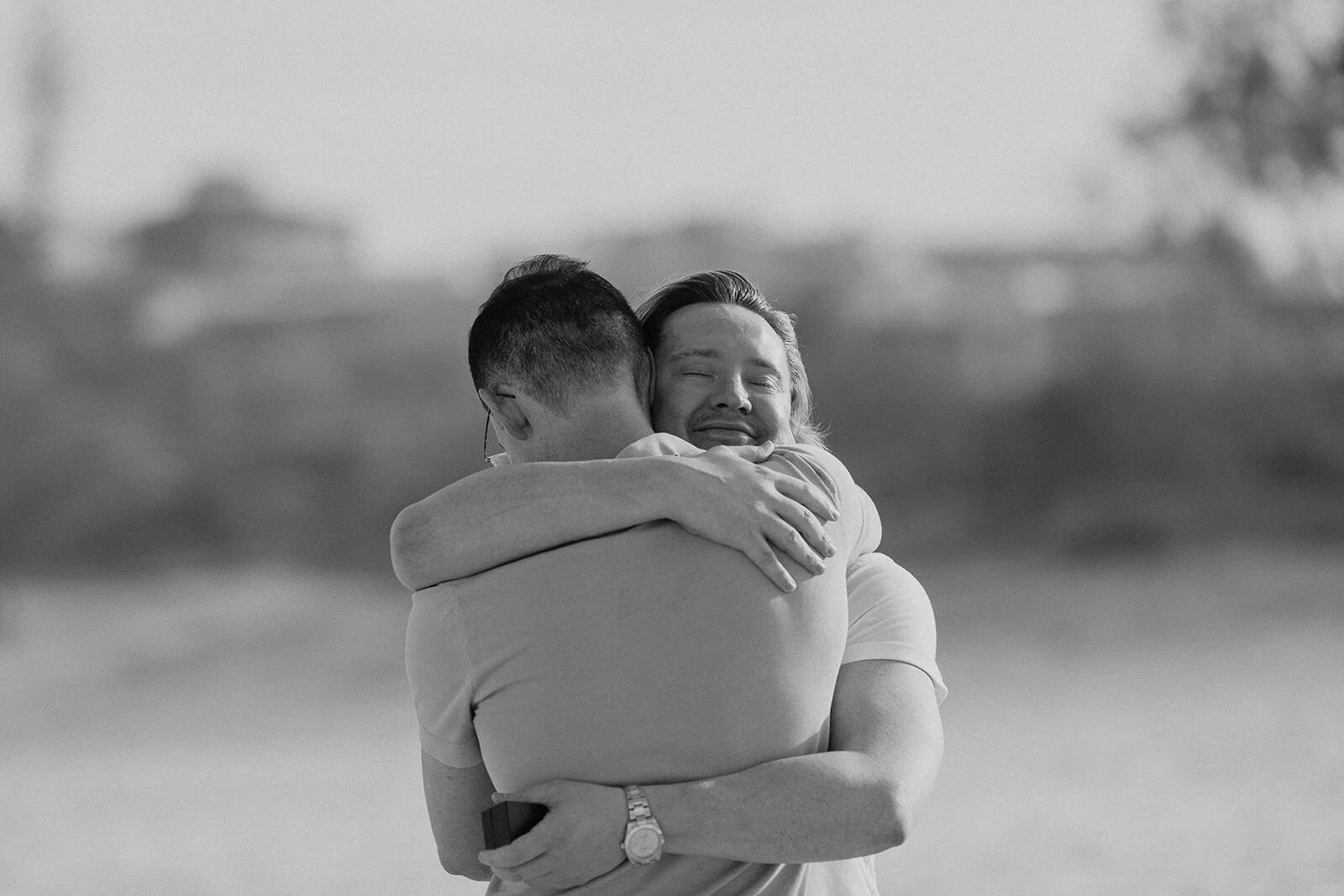 Black and white of the couple hugging tightly after the proposal, Byron and Luke's marriage proposal at Cabarita Beach, Northern Rivers