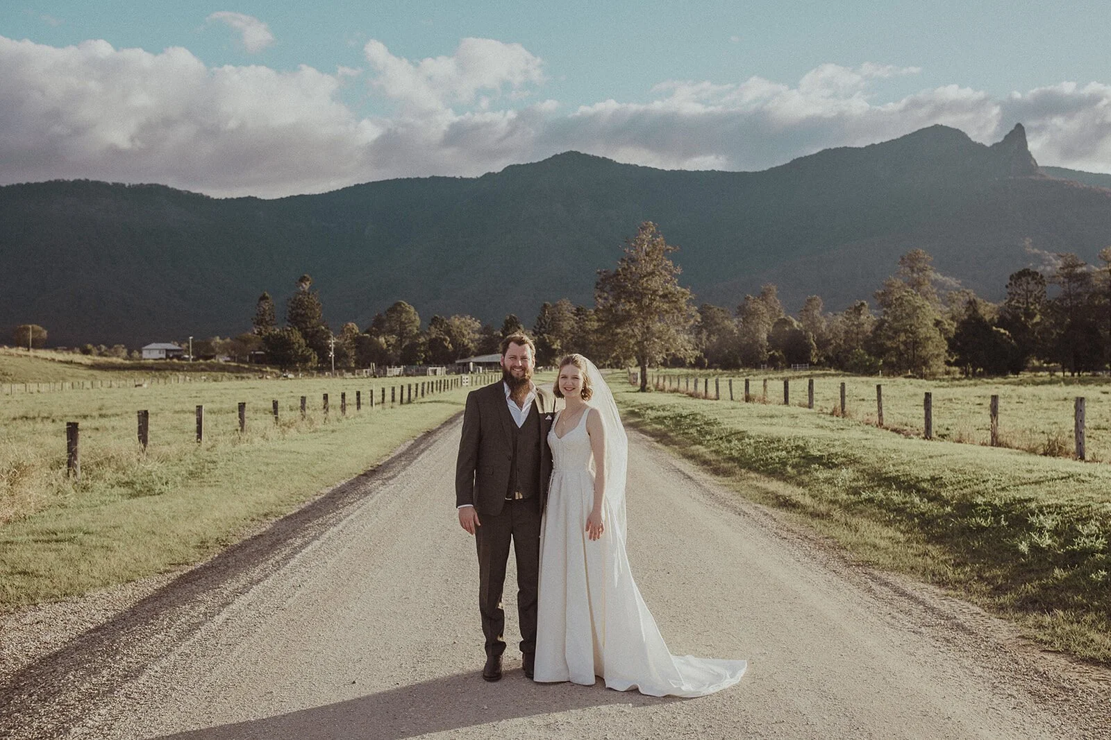 Couple standing on a country road with the mountain range behind, Sam and Tom's elopement at Highfield Farm, Northern Rivers