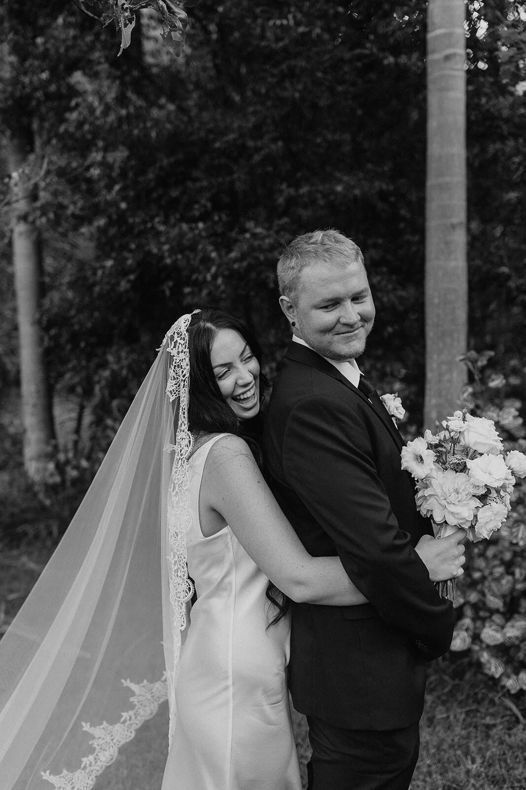 Black and white of the bride hugging the groom, Kobi and Darren's elopement at Butterfly Lane, Byron Bay hinterland