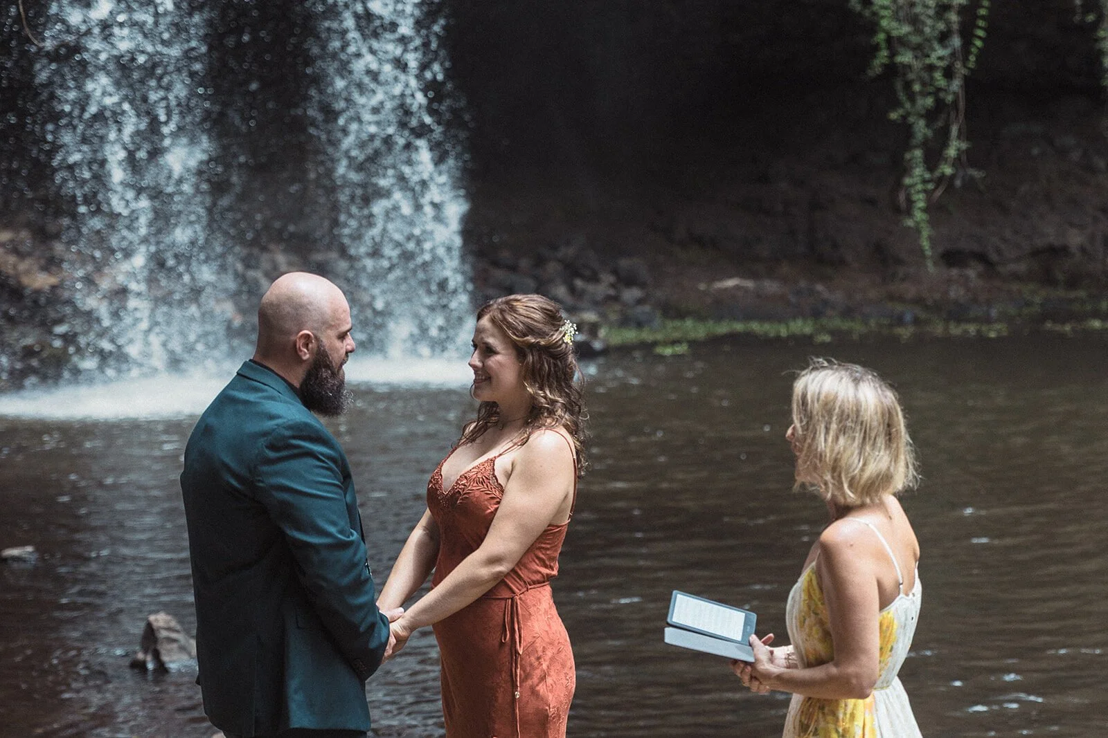 Close view of the couple holding hands as the celebrant reads, Sara and Graeme's elopement at Killen Falls, Northern Rivers