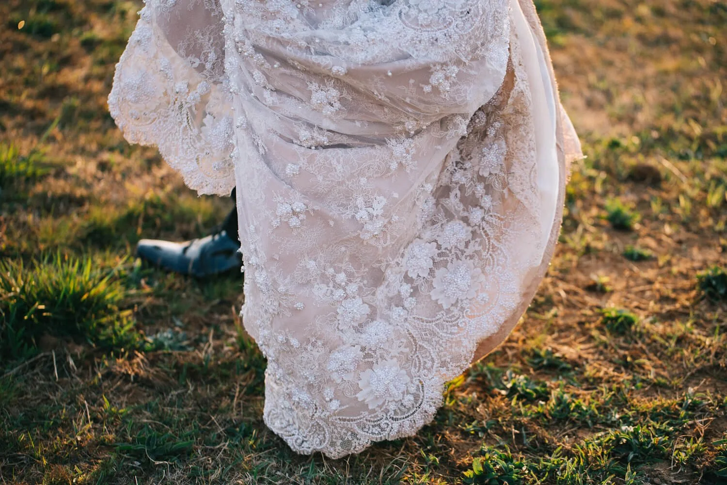 Blush lace wedding gown trailing through autumn grass in the Southern Highlands