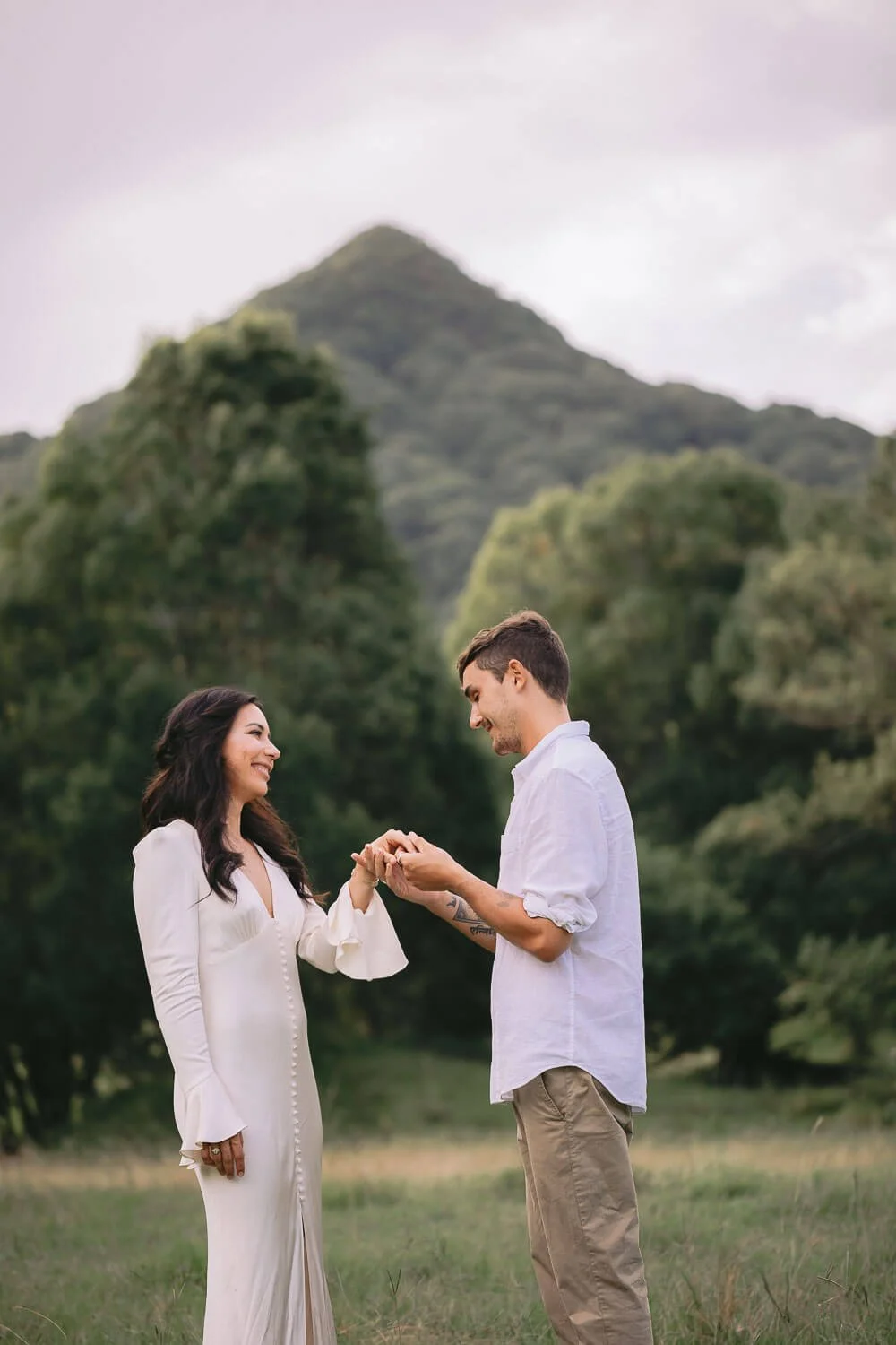 Couple exchanging rings in front of Mount Chincogan during their weekday elopement