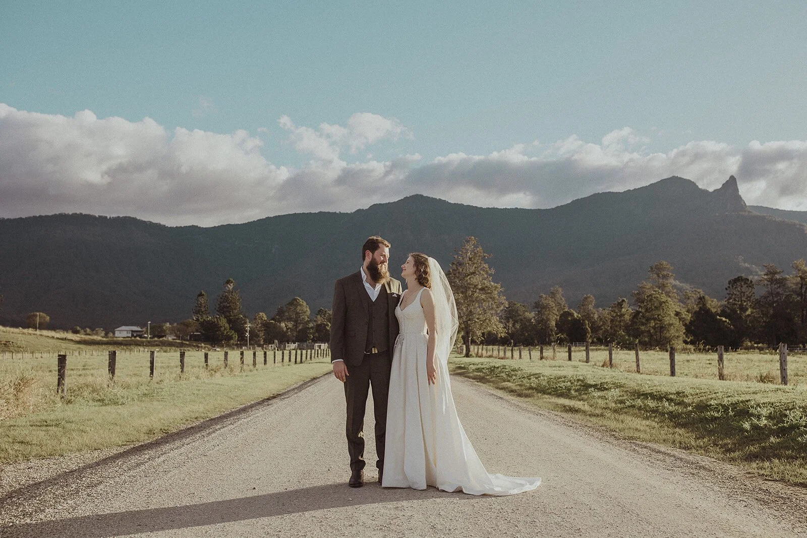 Couple on a country road with mountains behind, Sam and Tom's elopement at Highfield Farm, Northern Rivers