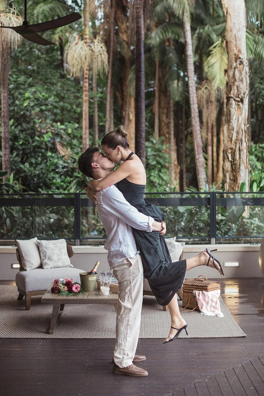 Man lifting his fiancée into a kiss, Ben and Chloe's marriage proposal in Byron Bay
