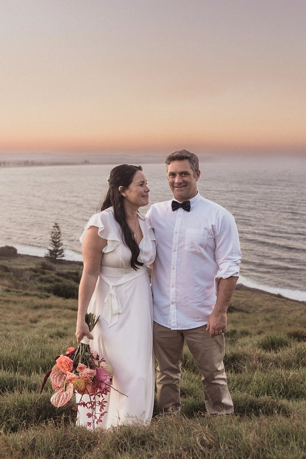 Couple smiling together in the pink sunset, Maritess and Mark's elopement at Lennox Head