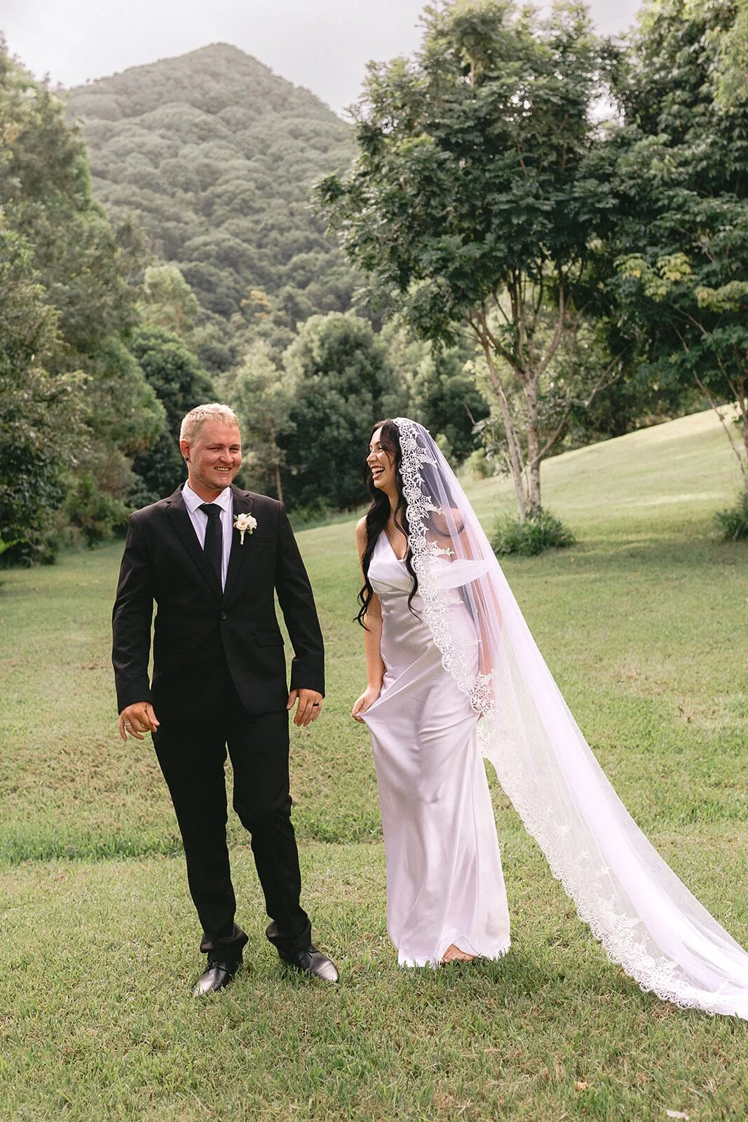Couple smiling at each other on the grass, Kobi and Darren's elopement at Butterfly Lane, Byron Bay hinterland