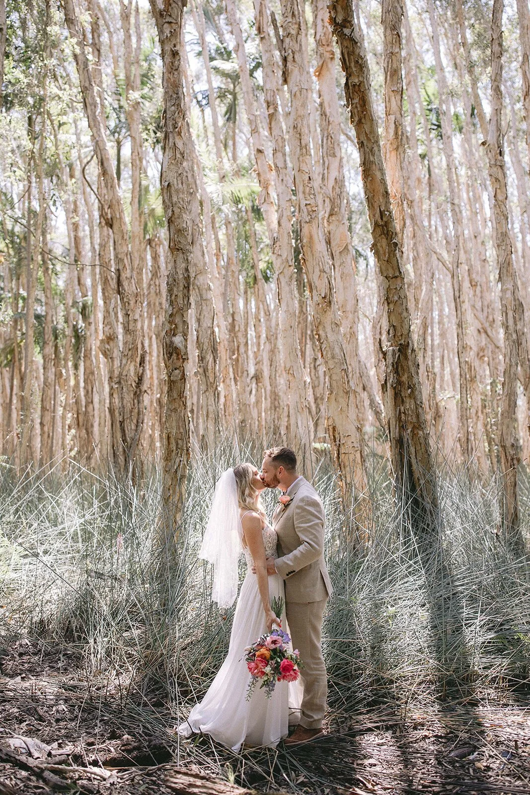 Couple kissing in a paperbark forest, Eliza and Greg's elopement at Broken Head, Byron Bay