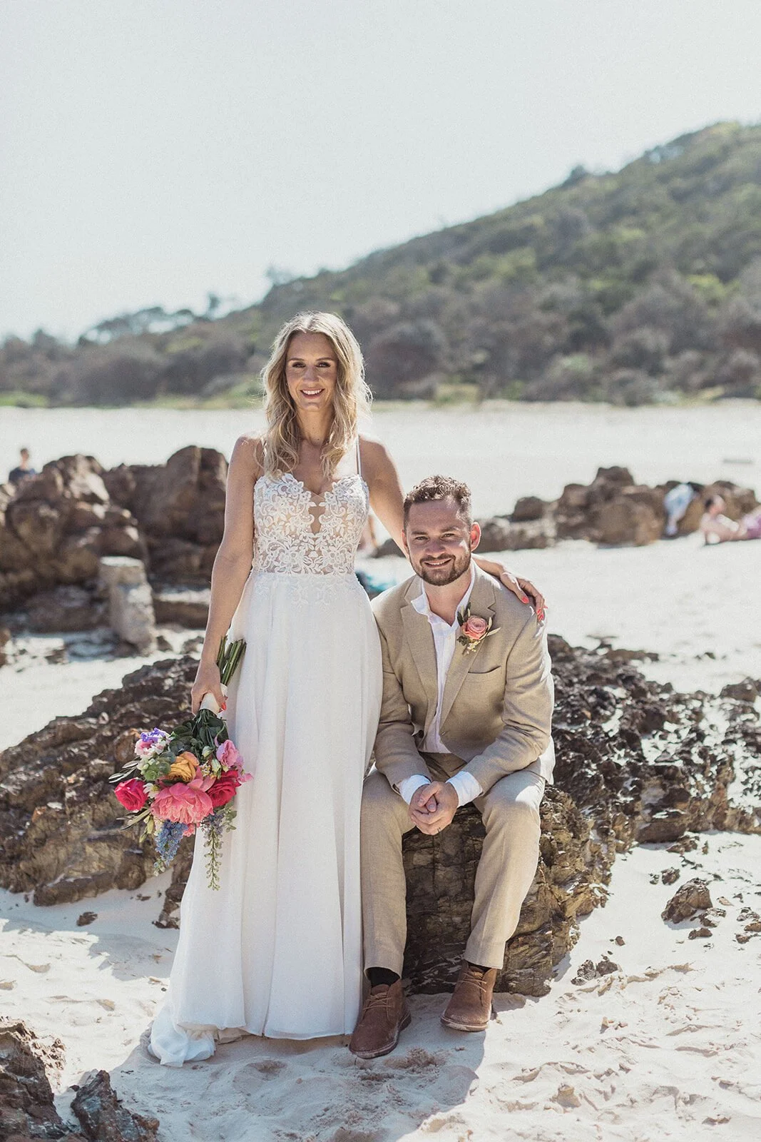 Couple posing among the rocks on the beach, Eliza and Greg's elopement at Broken Head, Byron Bay