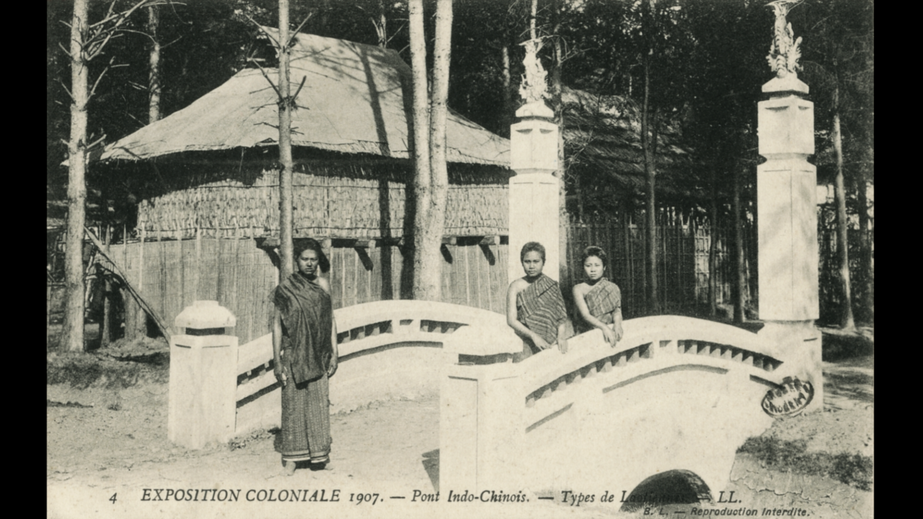 Une photo en noir et blanc de trois enfants chinois en vêtements traditionnels, debout sur un pont en pierre. En arrière-plan, une maison en bambou avec un toit en chaume et des arbres, dans un cadre forestier. La légende indique qu'il s'agit d'une e